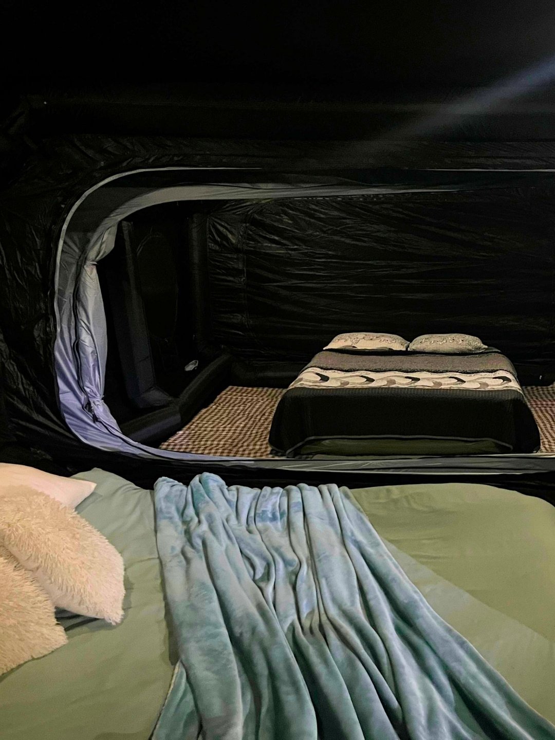Looking through the internal doorway of the Wander Cube Starlight from one bedroom into the second room with another made-up bed