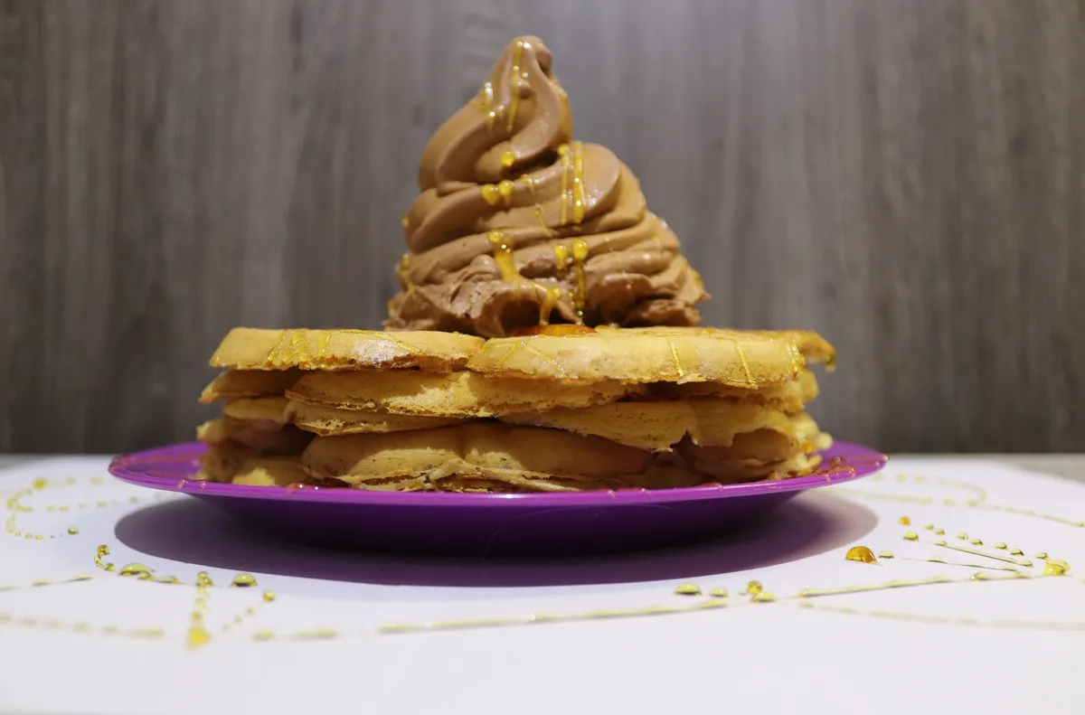 Golden waffles made with BosKampKos Grondseile waffle mix topped with chocolate at a campsite