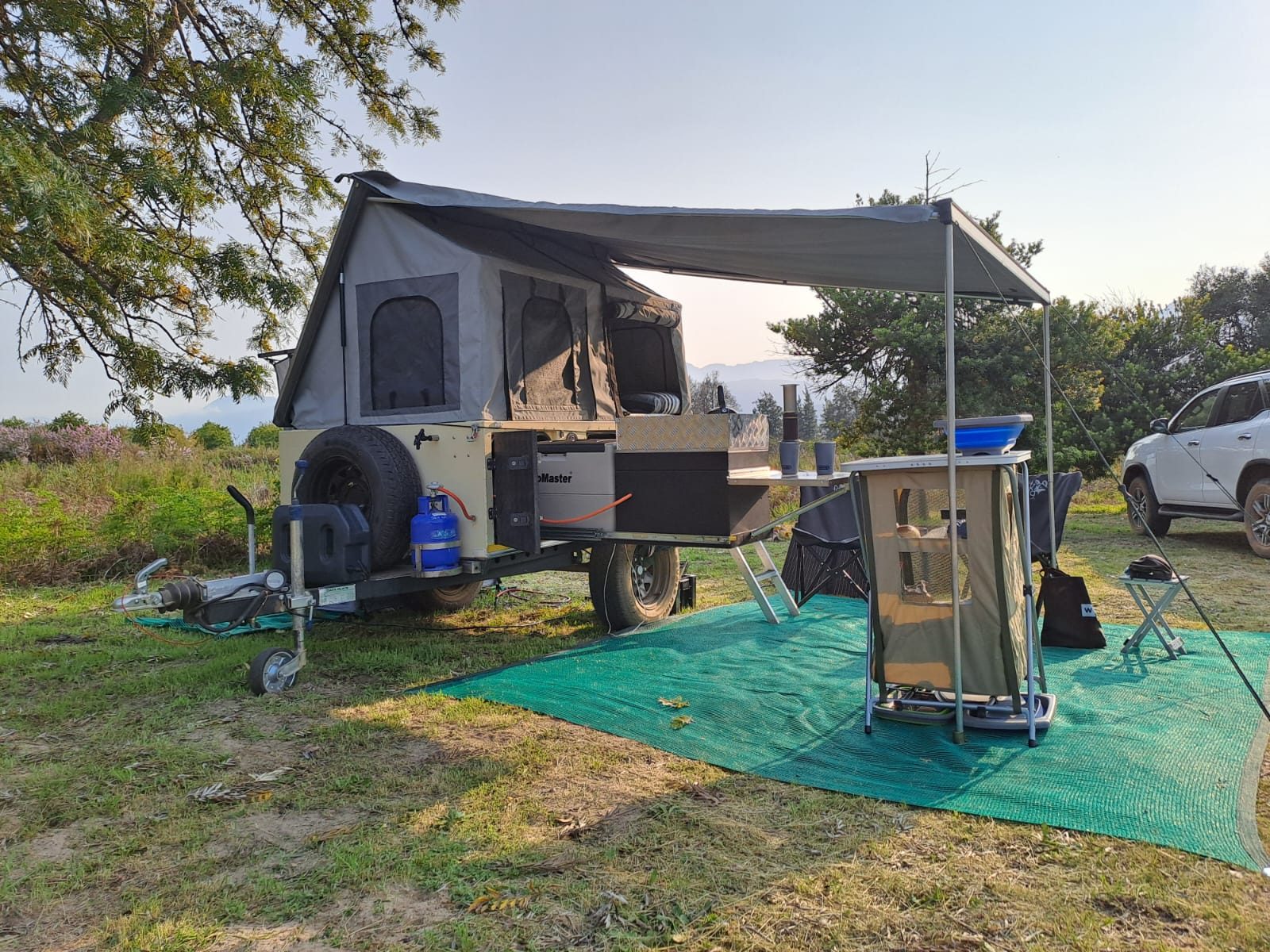 Moremi XLT off-road camping trailer fully set up at a campsite in South Africa with awning and outdoor kitchen