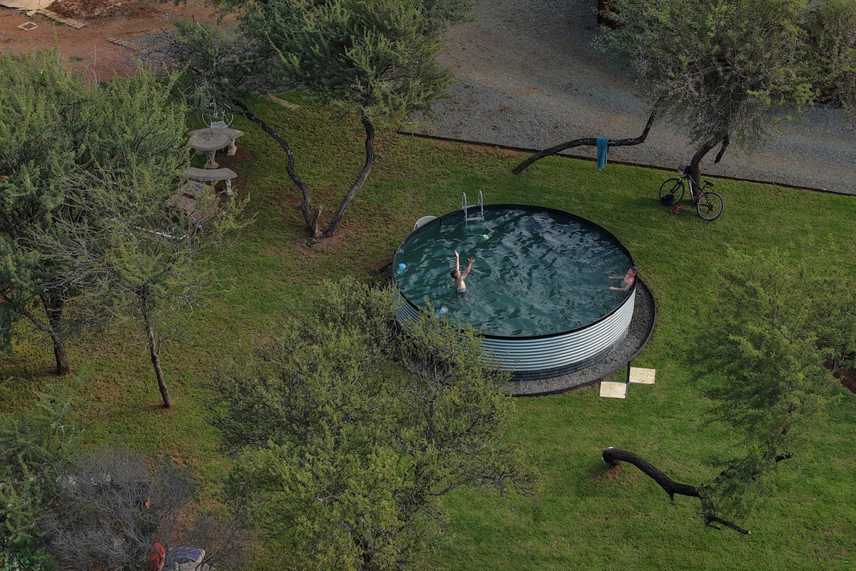 The swimming pool at Plaas Toe farm surrounded by bushveld trees in Dinokeng Game Reserve